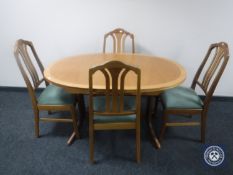 A Parker Knoll teak oval extending dining table with four chairs