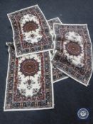 A set of four Persian design rugs on cream ground