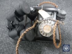 A black Bakelite cased telephone and pair of Tasco binoculars