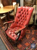 An Edwardian buttoned back red leather library armchair,