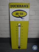 A mid 20th century Duckhams Motor Oil enamelled sign with thermometer