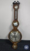 An early 20th century oak aneroid banjo barometer with silvered dial