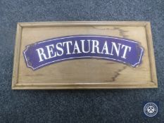 An enamelled restaurant sign mounted on a pine board
