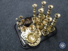 A tray of assorted brass ware, candlesticks and candle holders, ash trays,