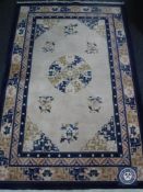 A fringed Chinese rug on blue ground