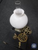 A tray of chrome oil lamp with glass chimney and shade, brass toasting fork, two brass trivets,