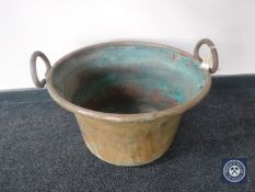 A large antique copper twin handled cooking pot