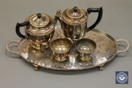 A twin-handled silver plated tray containing a four-piece tea set