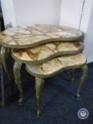 A nest of three gilt metal and onyx kidney shaped tables