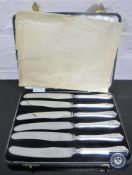 A set of six cased silver-handled butter knives