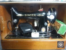 A cased vintage Singer electric sewing machine
