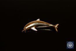 An 18ct two-tone gold dolphin brooch, with sapphire-set eye, length 47mm.