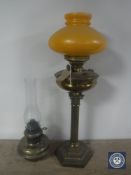 A Victorian Duplex brass Corinthian column oil lamp with orange glass shade plus a further oil lamp