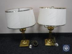 A pair of decorative brass table lamps with shades