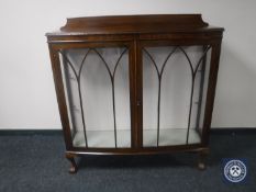 A 20th century walnut display cabinet on claw and ball feet