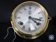 A circular Viking brass ship's clock with key