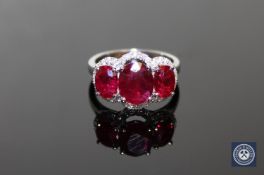 A 14ct white gold ruby and diamond ring, three oval-cut deep red rubies weighing a total of 5.