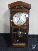 An early 20th century mahogany cased eight day wall clock with pendulum and key