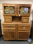 A mid 20th century kitchen storage cabinet with advertising decoration,