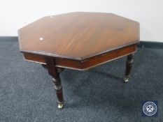 A Victorian mahogany octagonal table on brass castors