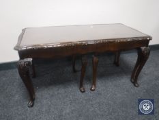 A mahogany glass topped coffee table fitted two table beneath