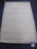 A hand tufted border design beige rug, 120 cm x 180 cm, rrp £297.