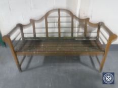 A teak scroll arm garden bench