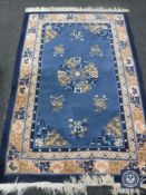 A fringed Chinese rug on blue ground