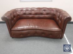 A brown button leather shaped settee