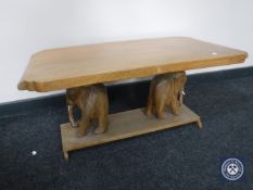 A 20th century coffee table on elephant supports