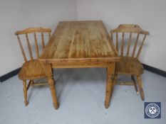 A pine kitchen table with two chairs