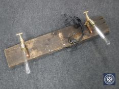 Two brass taps mounted on an oak board,
