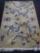 A fringed Chinese embossed rug of dragon design on yellow ground