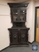 A Victorian carved and ebonised oak standing corner cabinet,