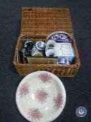 A wicker basket containing assorted china including Ringtons teapot and wall plates,