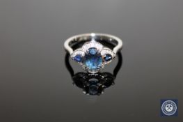 A 14ct white gold sapphire and diamond ring, an oval-cut deep-blue sapphire weighing 0.
