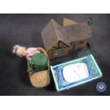 A mid 20th century cottage doll's house together with a wicker and plastic doll's crib containing