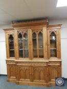 A heavily carved pine breakfront glazed bookcase,