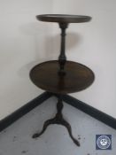 A mahogany two tier pedestal wine table