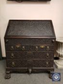 A George III and later carved oak fall-front bureau,