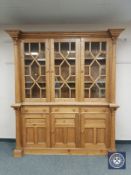 A carved pine inverted breakfront glazed bookcase,