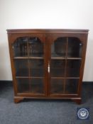 A mahogany double door glazed bookcase on bracket feet