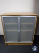 A contemporary double door cabinet with frosted glass doors