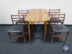 A teak effect drop leaf kitchen table together with four teak dining chairs
