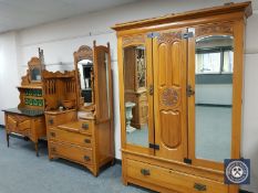 A three-piece Art Nouveau walnut bedroom suite, comprising mirror door wardrobe,