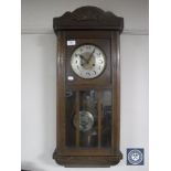 An early 20th century oak wall clock with silvered dial