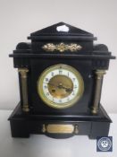 A Victorian black slate presentation mantel clock with brass pillar supports