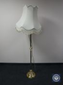 A brass standard lamp with shade
