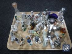 A tray containing a quantity of continental miniature figurines, glass perfume bottles,