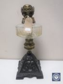 A Victorian oil lamp with glass reservoir on cast metal base